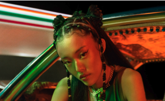 Black Gen Z woman sitting in a car outside 7-Eleven looking into the camera