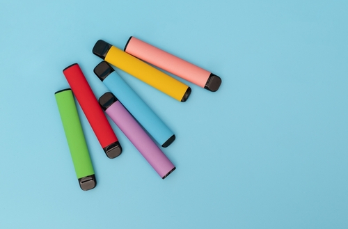 Multiple colourful vapes on a blue background.